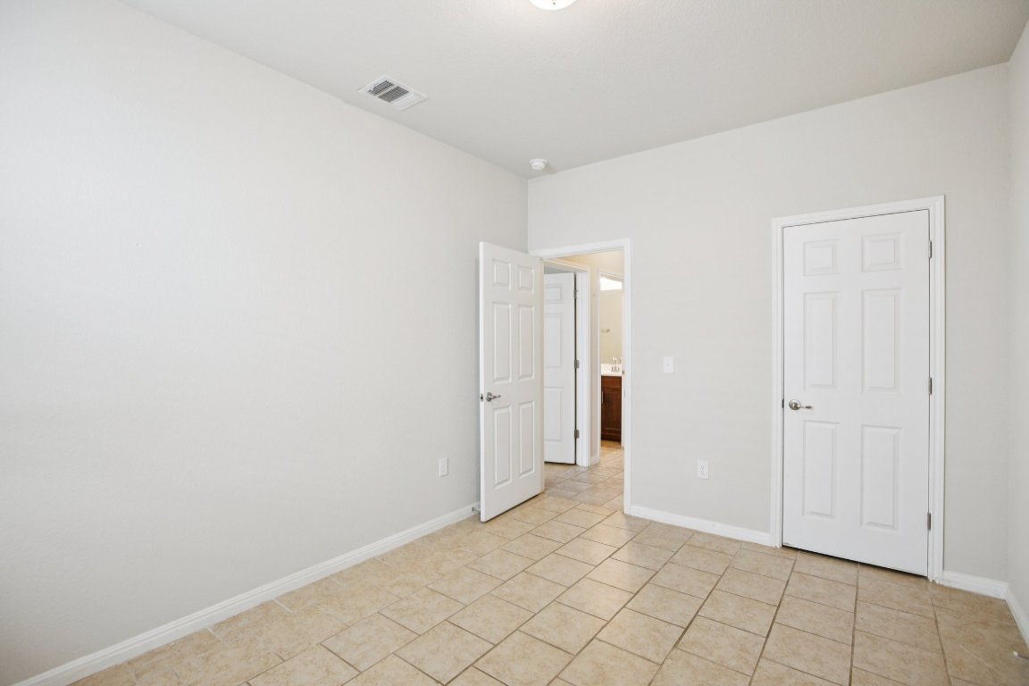 176 Mayney Ln. Leander, TX 78641 - Photo 27 of 34 Unfurnished bedroom featuring baseboards and light tile patterned floors