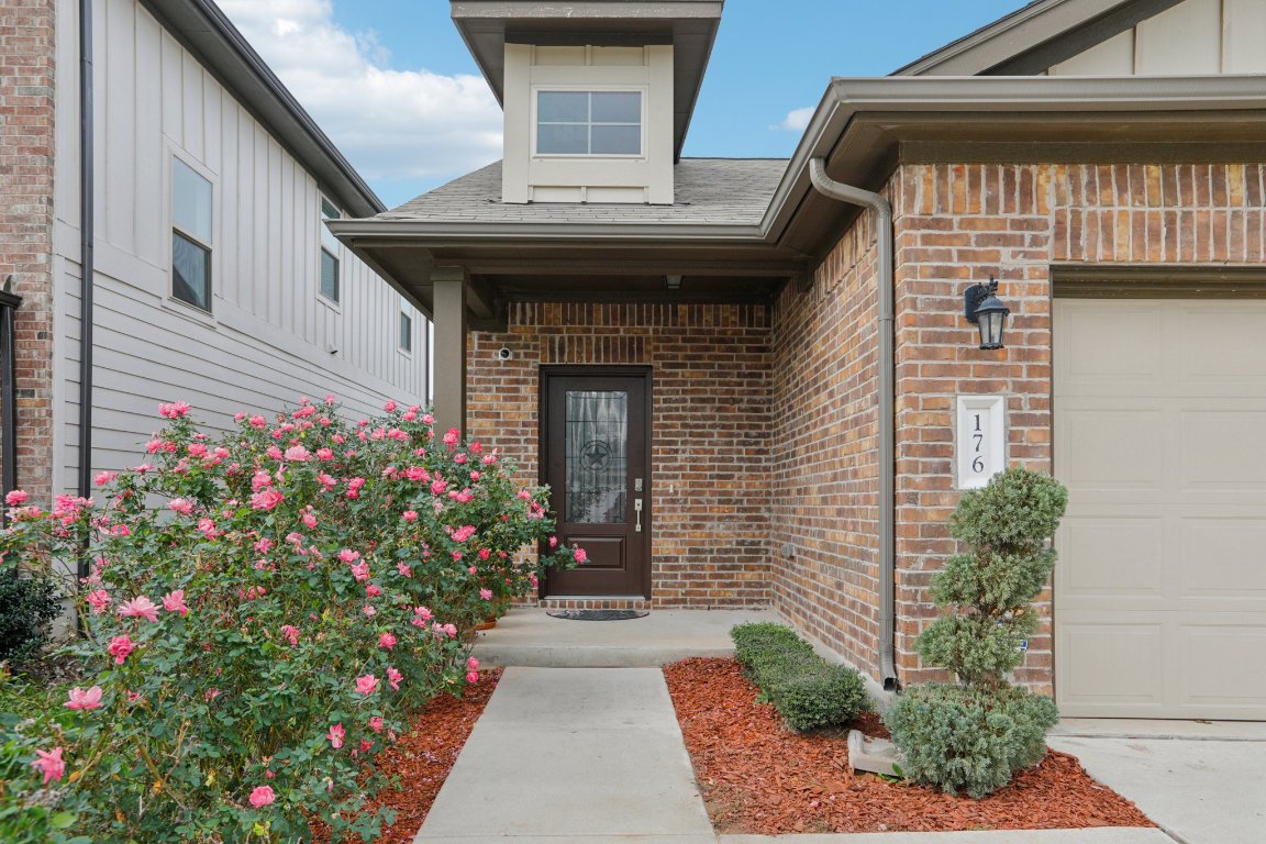 176 Mayney Ln. Leander, TX 78641 - Photo 3 of 34 Entrance to property featuring brick siding, a garage, and board and batten siding
