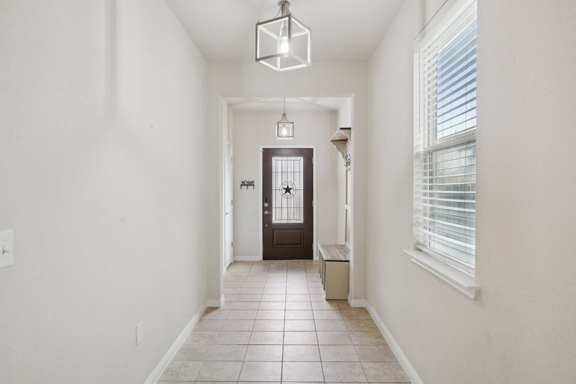 176 Mayney Ln. Leander, TX 78641 - Photo 4 of 34 Doorway with plenty of natural light, tile flooring, shoe & coat bench
