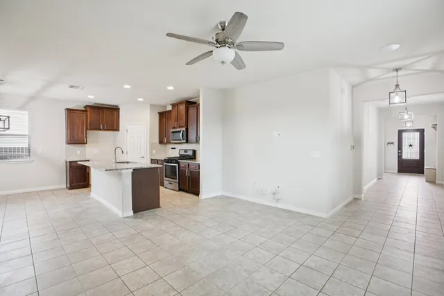 an empty room with white walls and ceiling fan