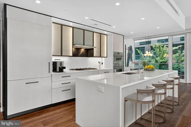 a kitchen with stainless steel appliances granite countertop a sink and a refrigerator