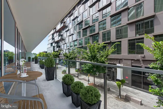 a balcony with potted plants and a bench