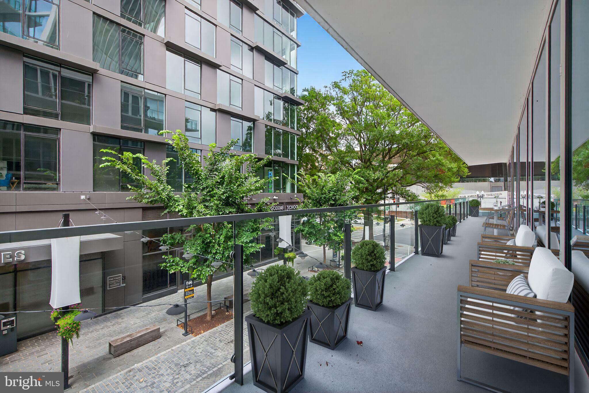 601 Wharf Street Southwest, Unit 213 Washington, DC 20024 - Photo 9 of 24 a balcony with potted plants and a bench