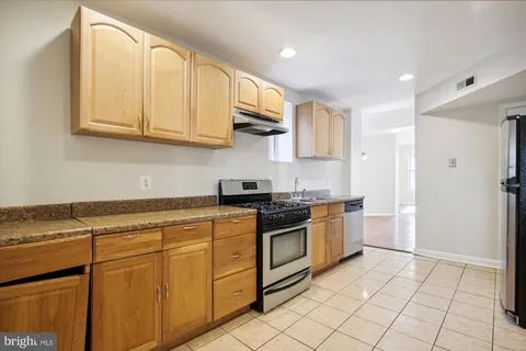 a kitchen with stainless steel appliances granite countertop a stove a sink and a refrigerator