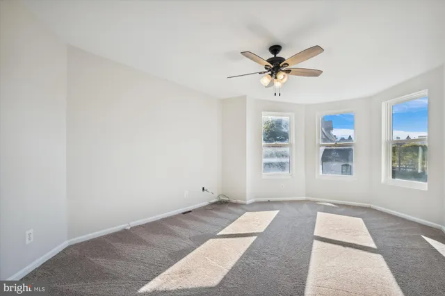 a view of a room with a ceiling fan and a window