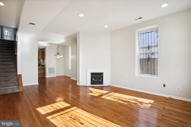 a view of empty room with wooden floor