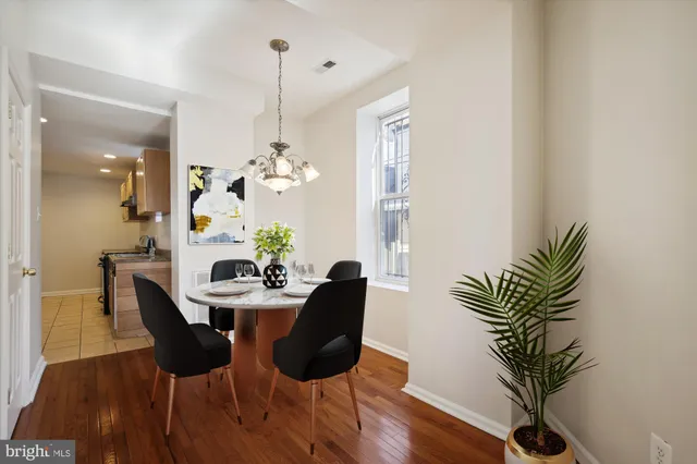 a dining room with furniture potted plants and wooden floor