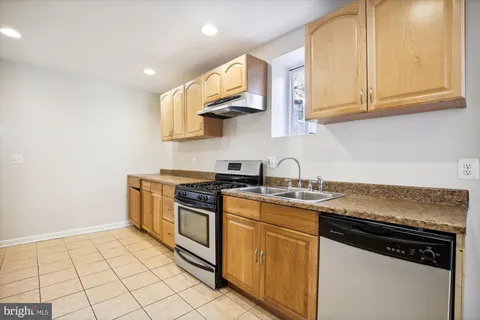 a kitchen with stainless steel appliances granite countertop a stove a sink and a white cabinets