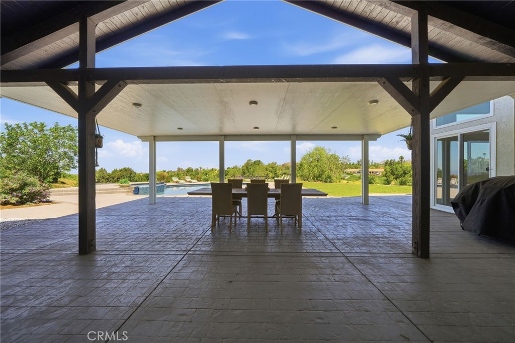 41110 Los Ranchos Circle Temecula, CA 92592 - Photo 48 of 77 a view of a patio with a table chairs potted plants and a barbeque