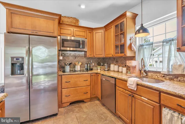 a kitchen with stainless steel appliances granite countertop a refrigerator and cabinets