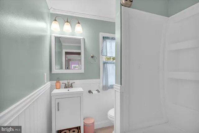 a bathroom with a sink mirror vanity and toilet