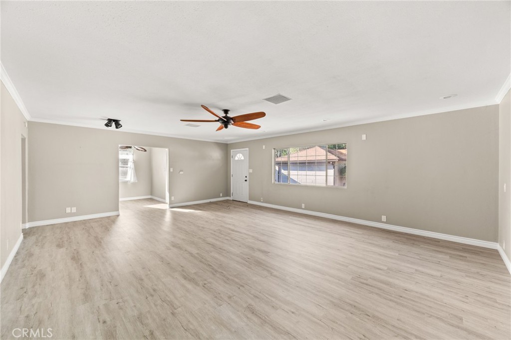 3869 Shamrock Avenue Riverside, CA 92501 - Photo 11 of 34 an empty room with wooden floor ceiling fan and windows
