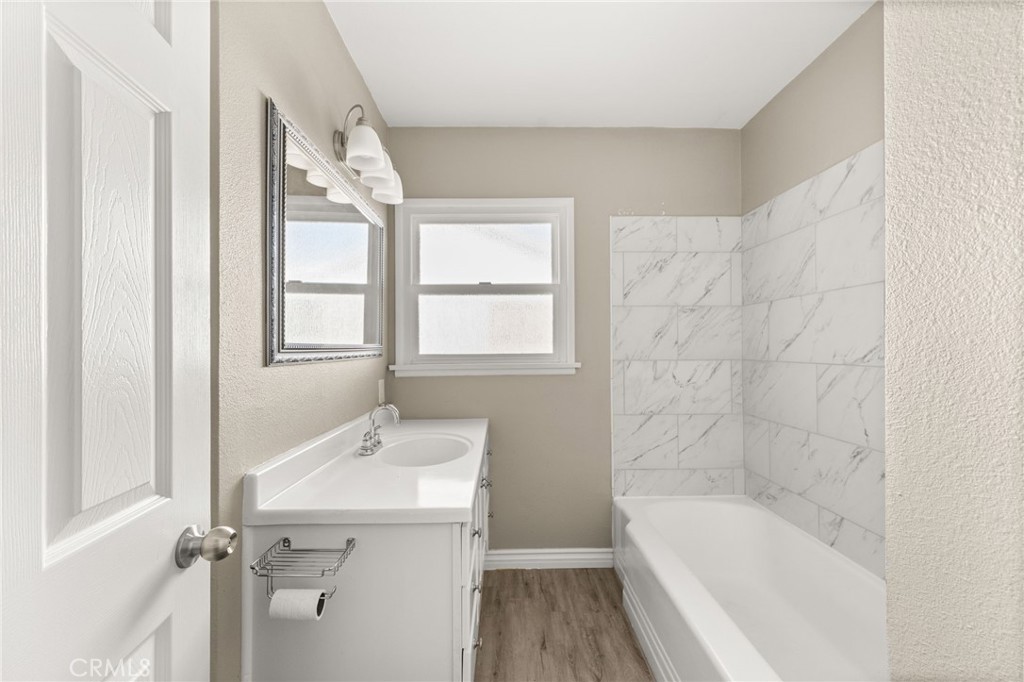 3869 Shamrock Avenue Riverside, CA 92501 - Photo 14 of 34 a bathroom with a bathtub a sink a window and a shower