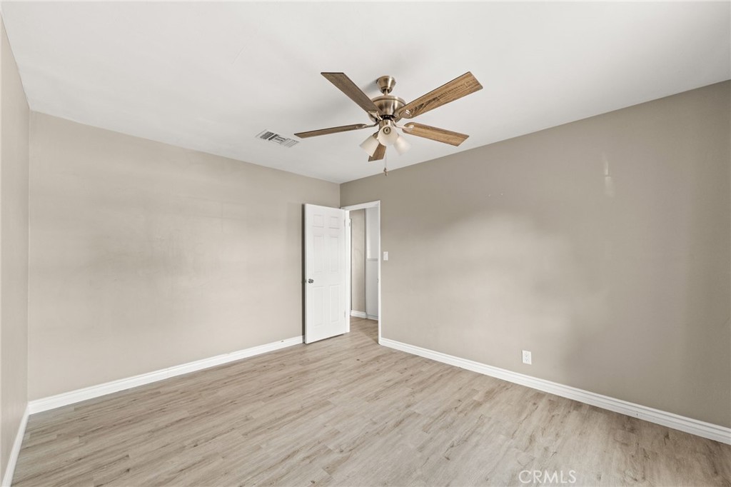 3869 Shamrock Avenue Riverside, CA 92501 - Photo 18 of 34 an empty room with wooden floor and a ceiling fan
