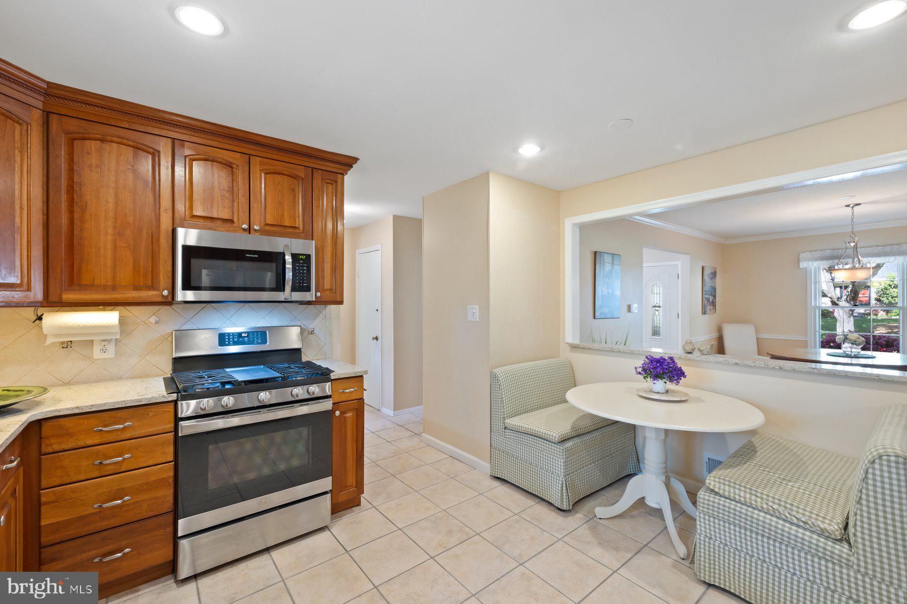 13820 Flint Rock Road Rockville, MD 20853 - Photo 18 of 50 a kitchen with stainless steel appliances a stove a sink cabinets and a dining table