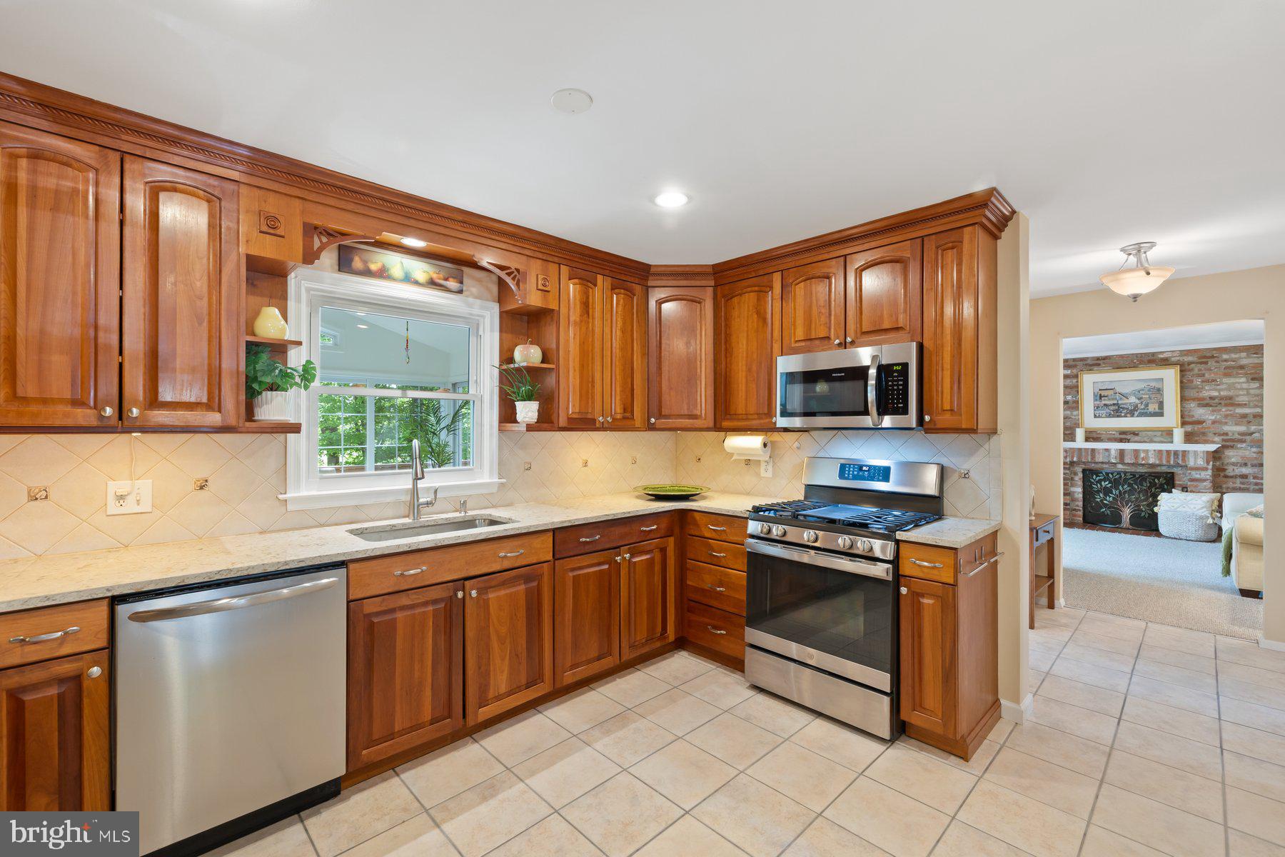 13820 Flint Rock Road Rockville, MD 20853 - Photo 19 of 50 a kitchen with stainless steel appliances granite countertop a stove top oven a sink dishwasher a dining table and chairs with wooden floor