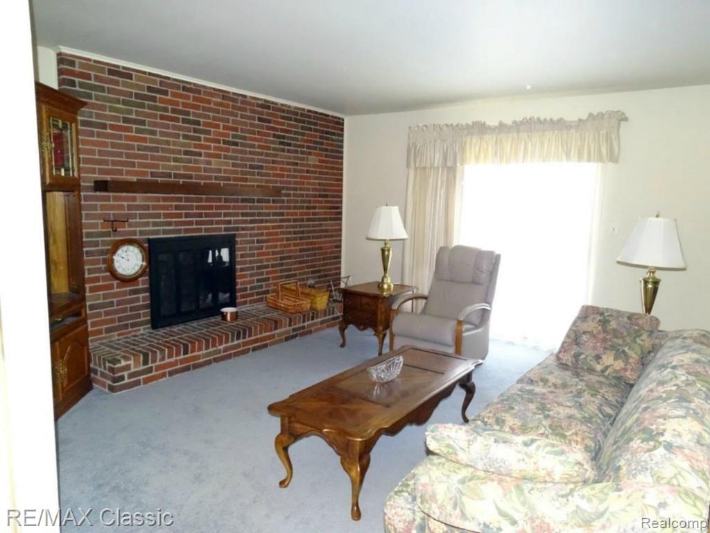 43952 Brandywyne Road Canton, MI 48187 - Photo 4 of 28 Natural Fireplace with wood storage, leads to doorwall out tot he backyard. Room is connected to dining room