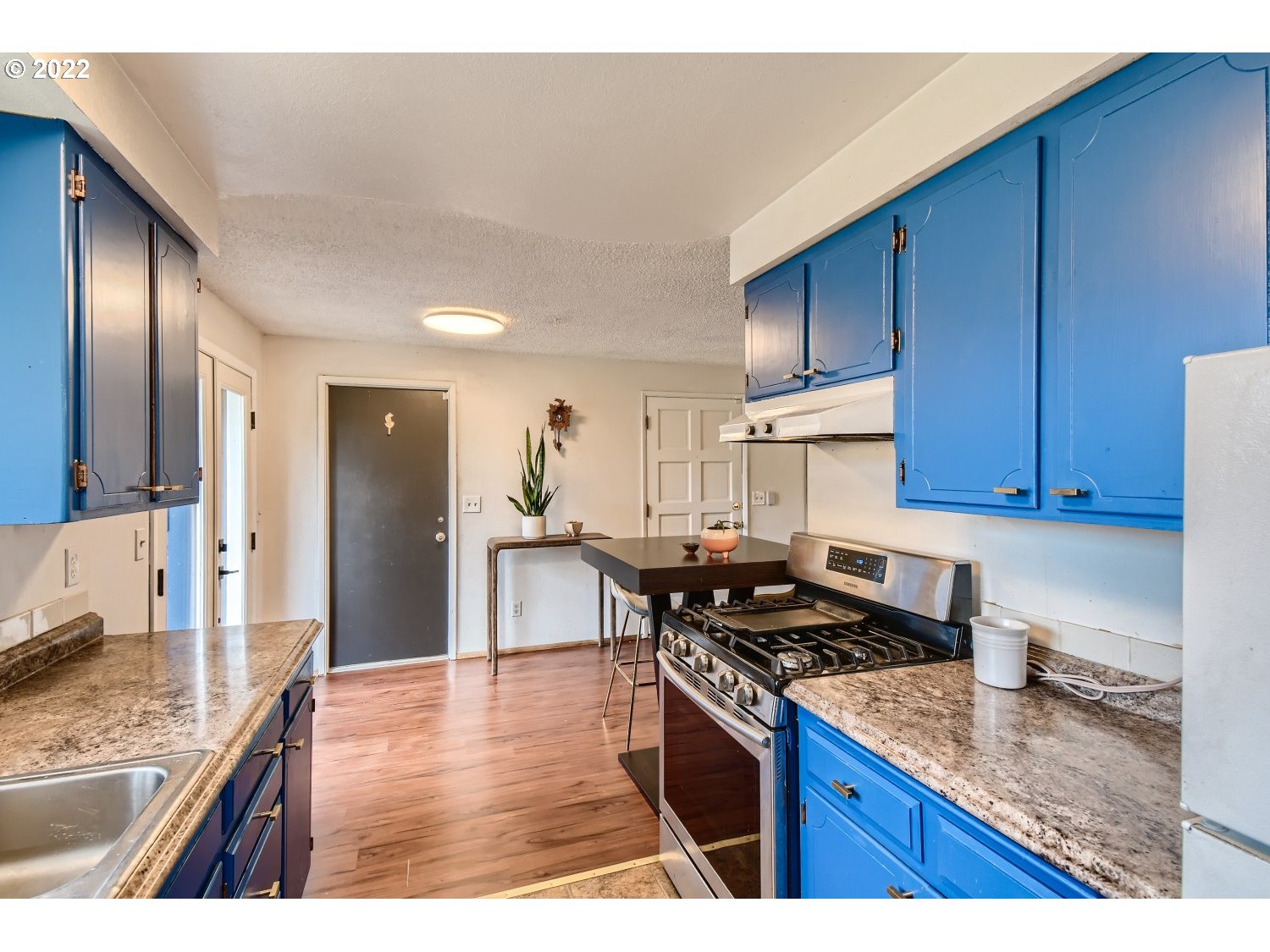 7109 North Sedro Street Portland, OR 97203 - Photo 12 of 28 a kitchen with granite countertop wooden cabinets and a stove top oven