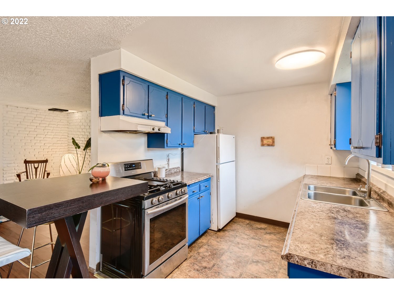 7109 North Sedro Street Portland, OR 97203 - Photo 10 of 28 a kitchen with stainless steel appliances granite countertop a stove a refrigerator and a sink