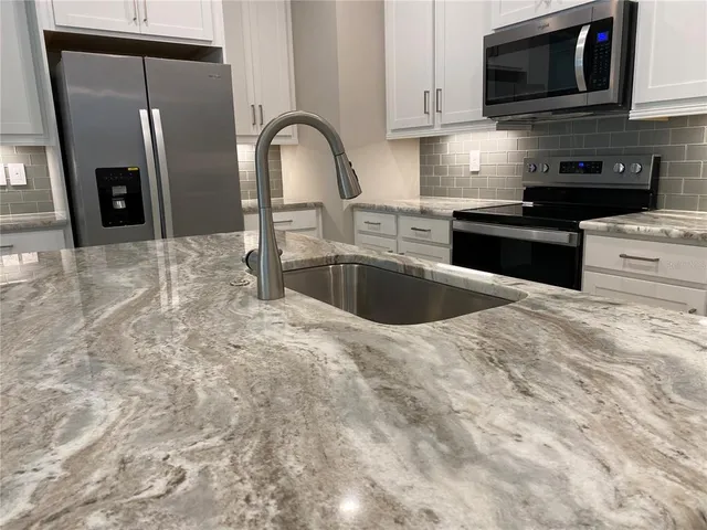 a kitchen with a refrigerator sink and cabinets