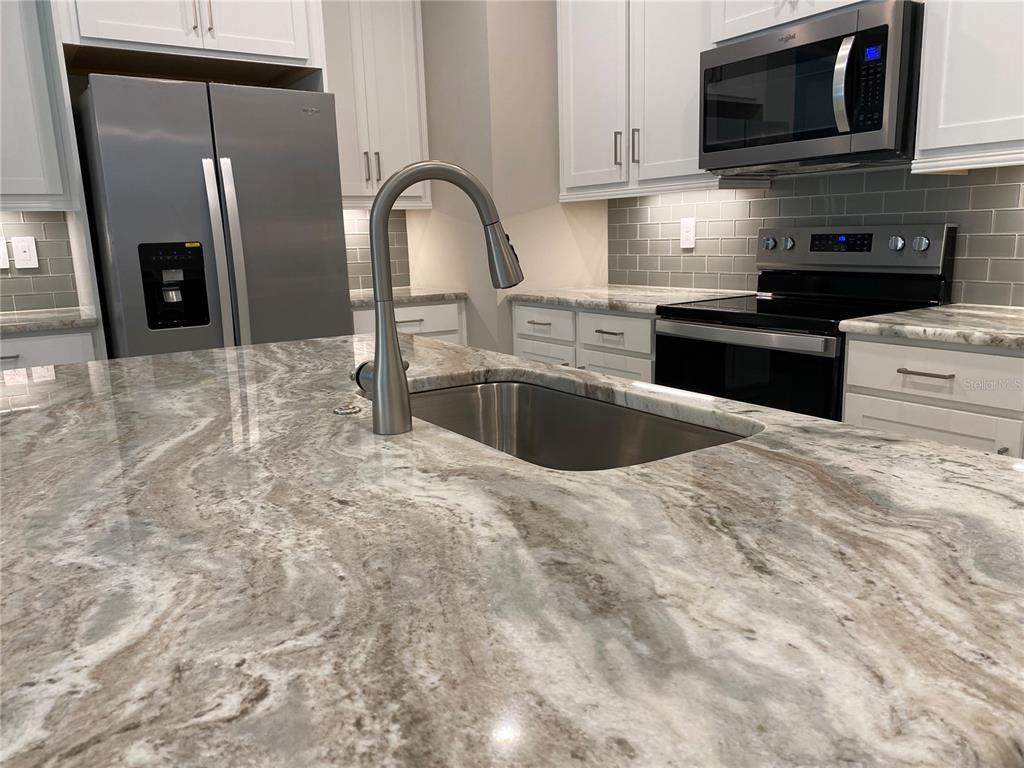 124 Soliera Street Nokomis, FL 34275 - Photo 11 of 43 a kitchen with stainless steel appliances granite countertop a sink a stove and microwave