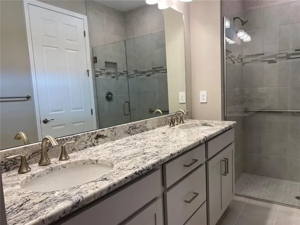 a bathroom with a granite countertop sink and a mirror