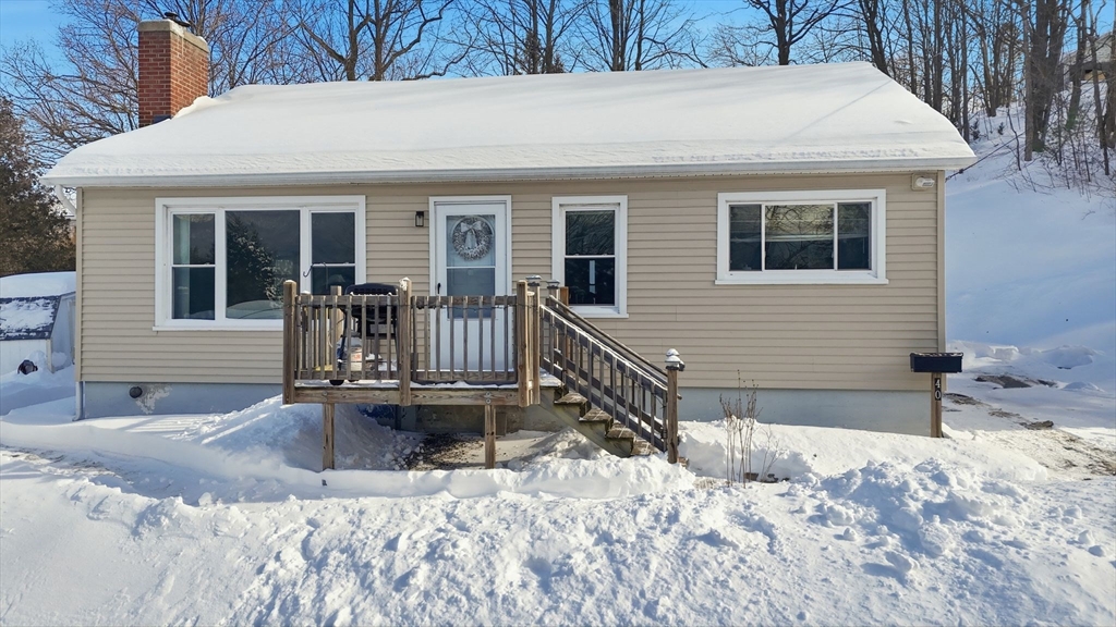 a view of a house with snow on the side of the road