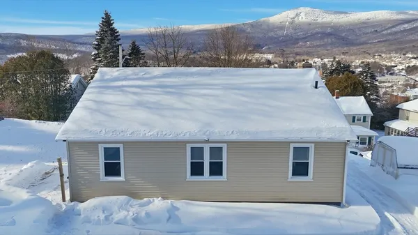 a front view of house with yard and mountain view in back
