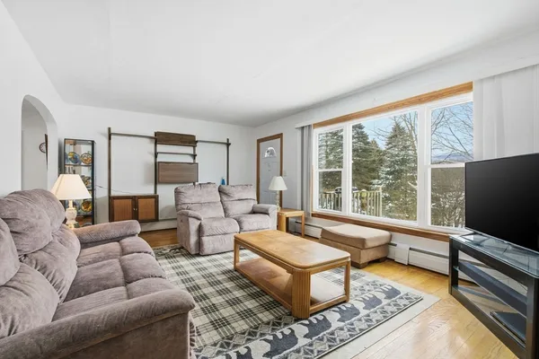 a living room with furniture flat screen tv and a large window