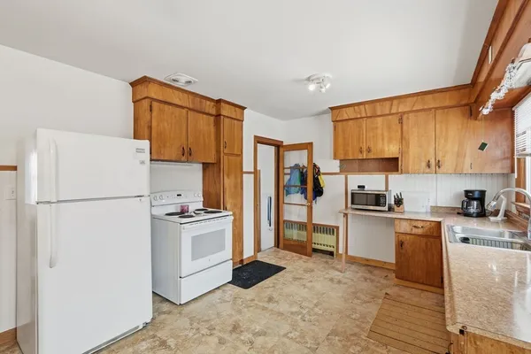 a kitchen with a refrigerator a stove top oven a sink and cabinets