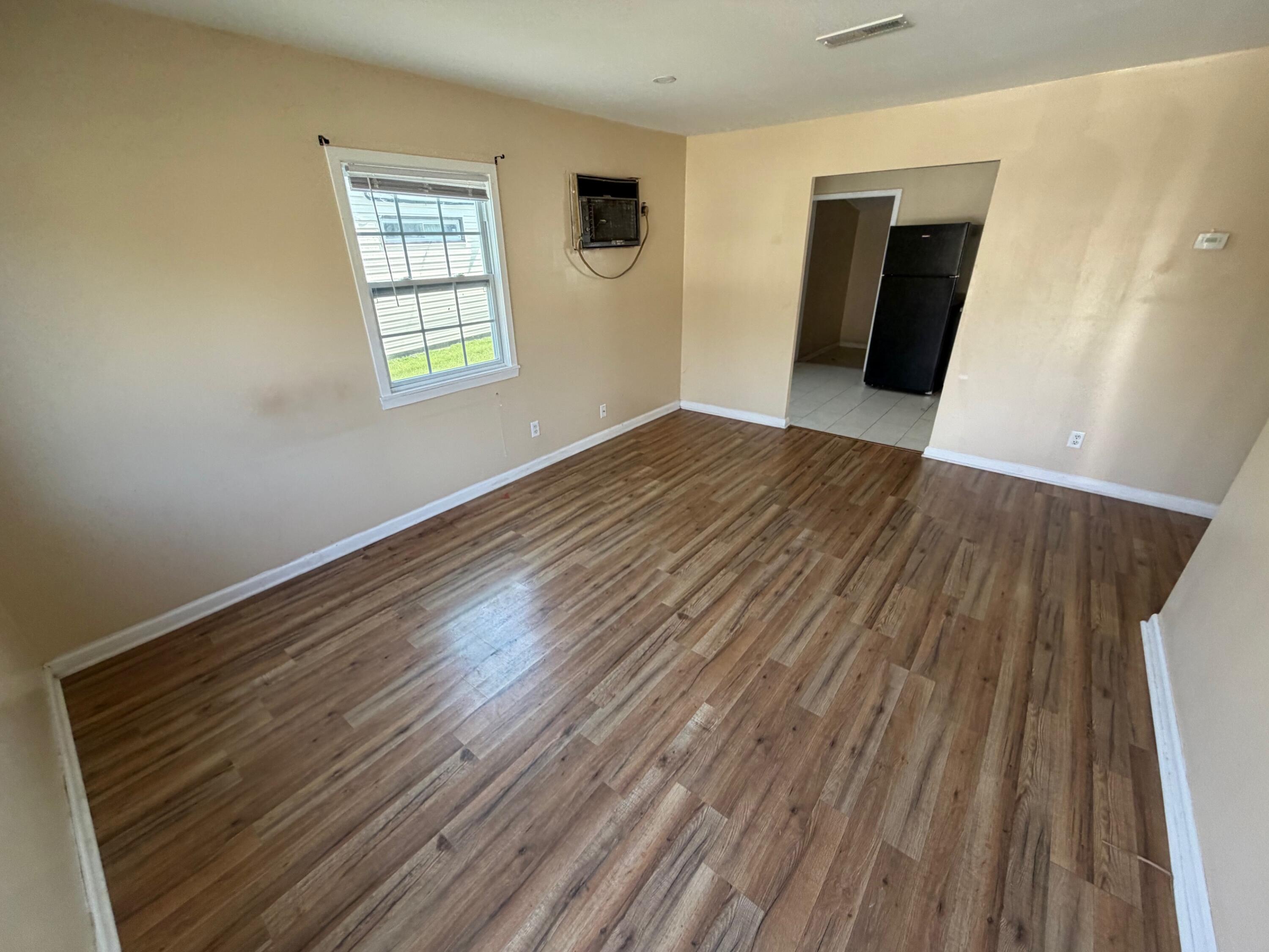 4247 West 19th Place Gary, IN 46404 - Photo 4 of 9 a view of an empty room with wooden floor and a window