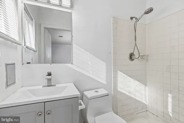 a bathroom with a sink a toilet and shower