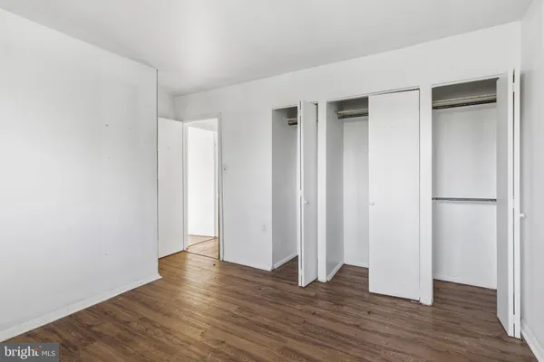 an empty room with wooden floor and closet