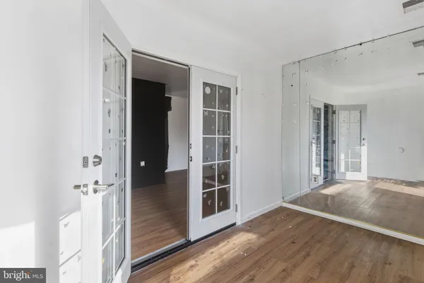 a view of a hallway with wooden floor and closet