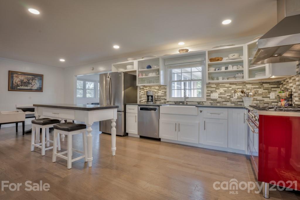 2667 Bill Collins Road Tryon, NC 28782 - Photo 29 of 48 a kitchen with stainless steel appliances kitchen island granite countertop a stove a sink a refrigerator and white cabinets