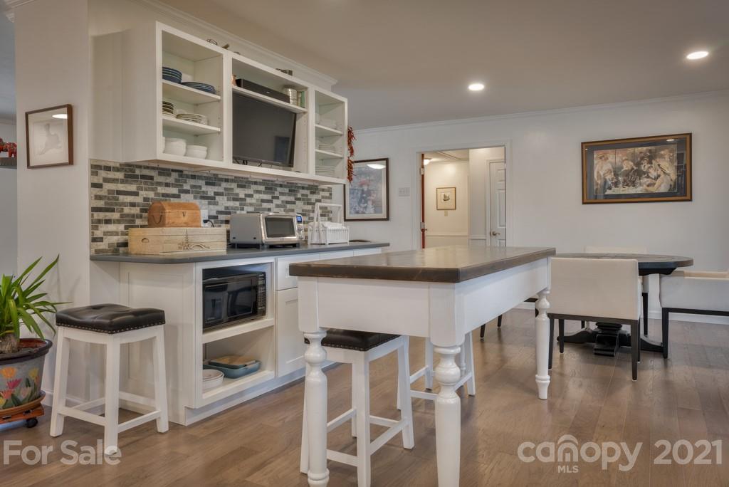 2667 Bill Collins Road Tryon, NC 28782 - Photo 30 of 48 a kitchen with stainless steel appliances granite countertop a table chairs and a wooden floor