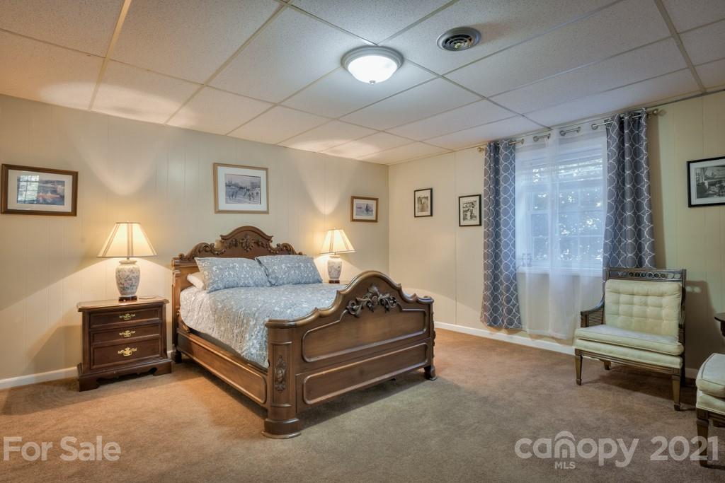 2667 Bill Collins Road Tryon, NC 28782 - Photo 47 of 48 a spacious bedroom with a bed and a couch