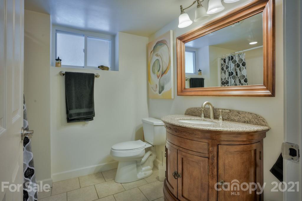 2667 Bill Collins Road Tryon, NC 28782 - Photo 48 of 48 a bathroom with a granite countertop sink toilet and mirror