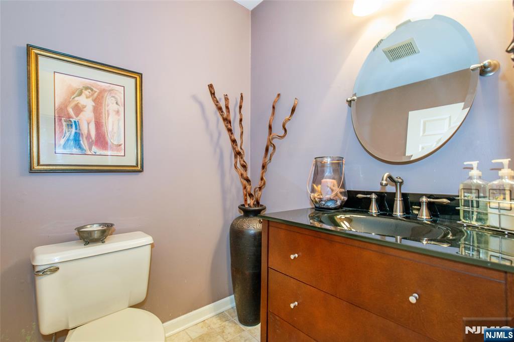 8 Tomahawk Drive Wayne, NJ 07470 - Photo 15 of 35 a bathroom with a toilet sink and mirror