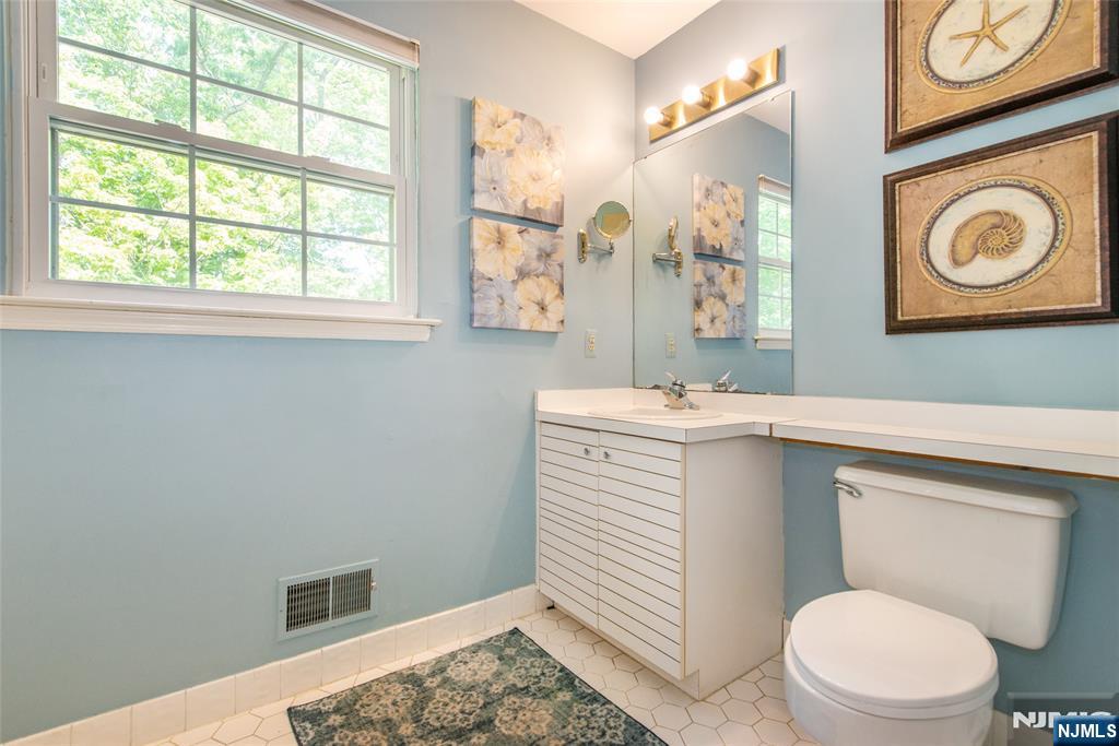 8 Tomahawk Drive Wayne, NJ 07470 - Photo 20 of 35 a bathroom with a sink a toilet and a mirror