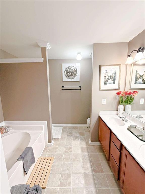 2708 Beynon Lane Northeast Suwanee, GA 30024 - Photo 27 of 38 a bathroom with a sink a mirror and a toilet