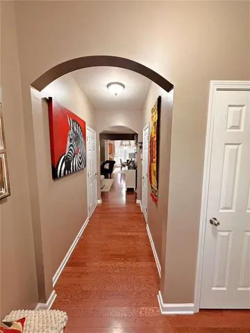 a hallway with wooden floor and closet