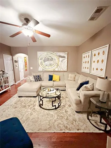 a living room with furniture and wooden floor
