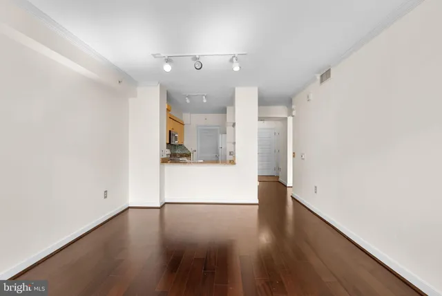 a view of a kitchen with a fridge and wooden floor