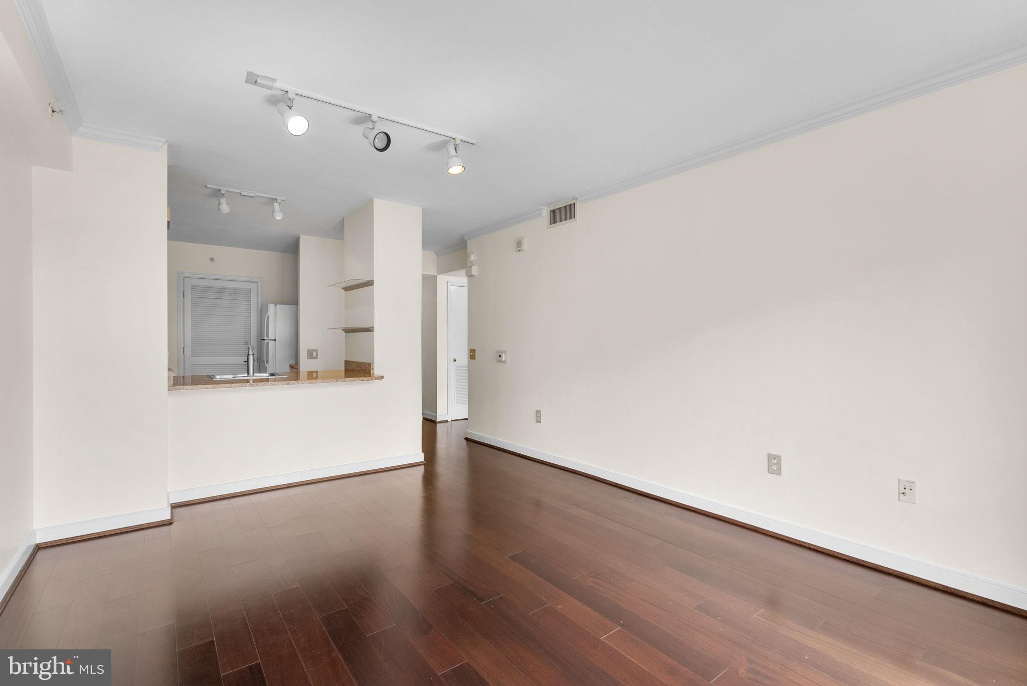 631 D Street Northwest, Unit 1129 Washington, DC 20004 - Photo 13 of 29 a view of a kitchen with a fridge and wooden floor