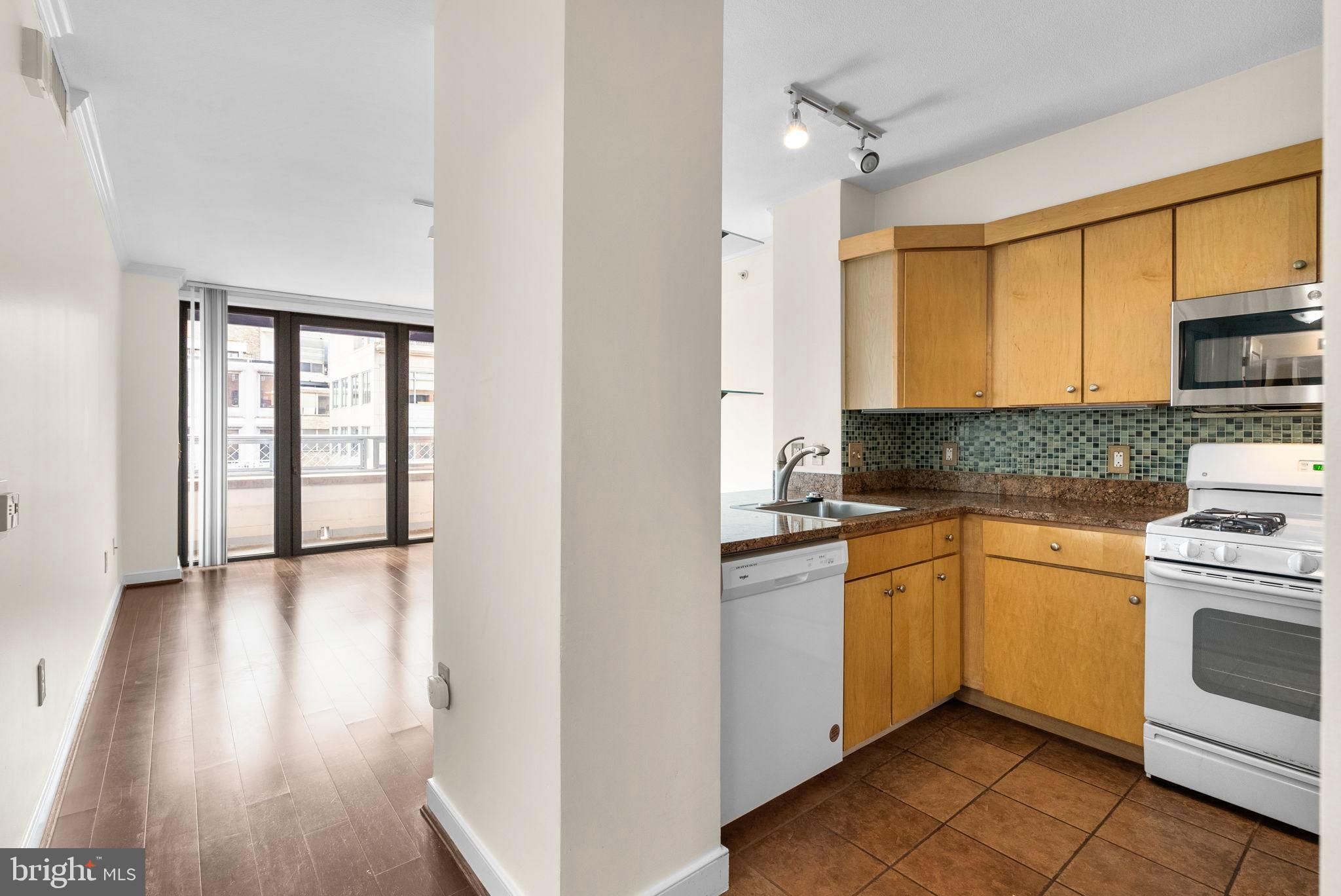 631 D Street Northwest, Unit 1129 Washington, DC 20004 - Photo 17 of 29 a kitchen with stainless steel appliances granite countertop a stove a sink and white cabinets
