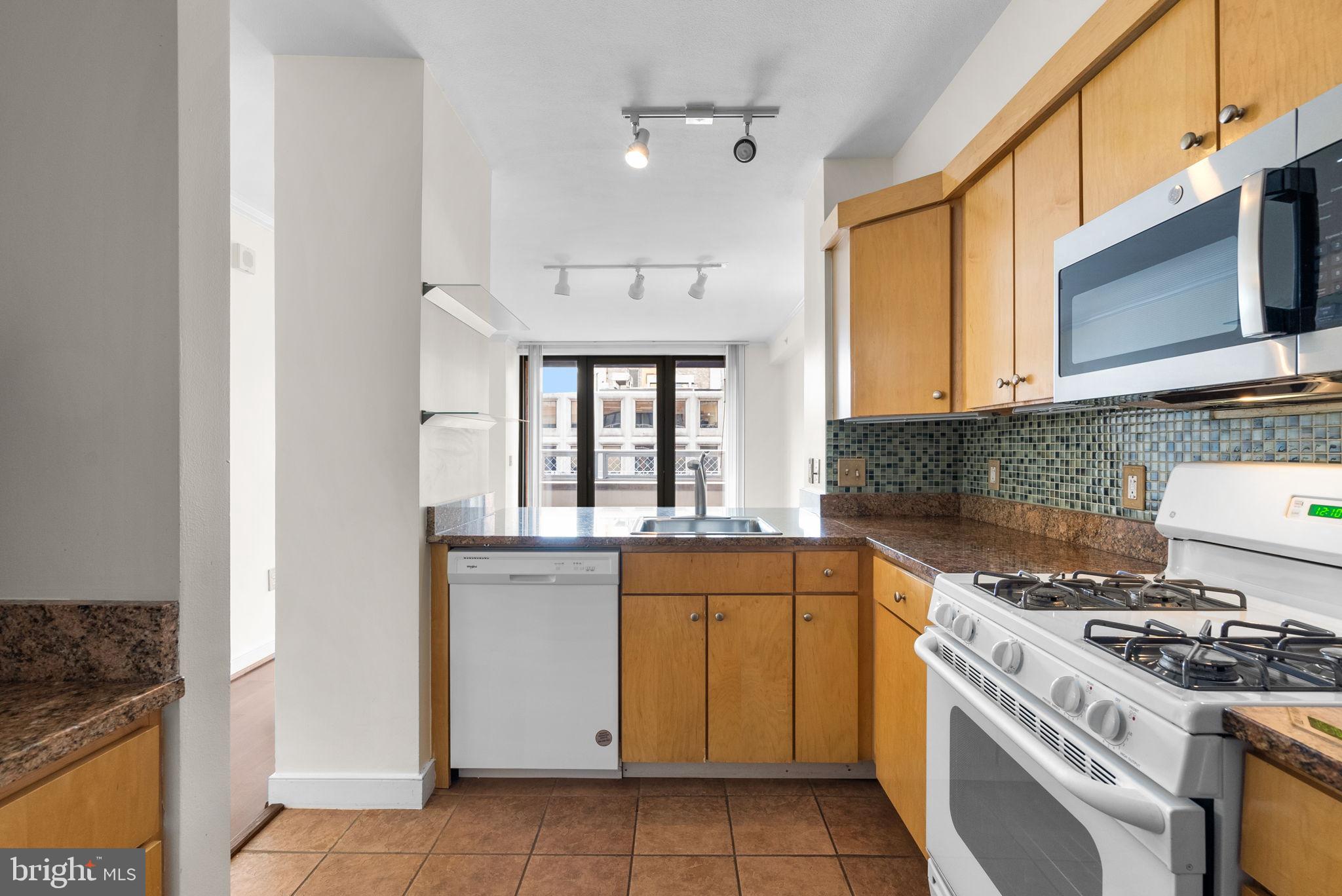 631 D Street Northwest, Unit 1129 Washington, DC 20004 - Photo 18 of 29 a kitchen with a stove top oven sink and cabinets