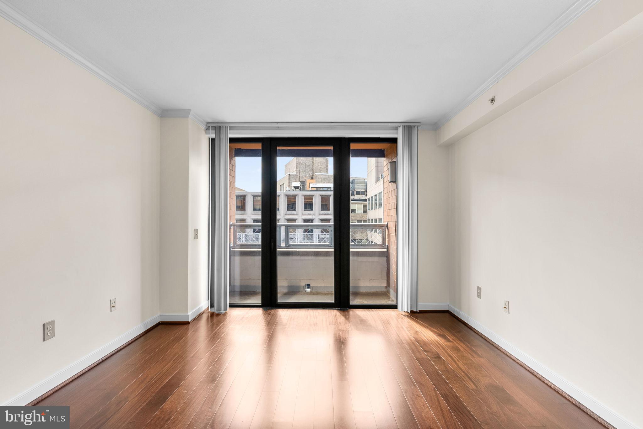 631 D Street Northwest, Unit 1129 Washington, DC 20004 - Photo 21 of 29 an empty room with wooden floor and windows