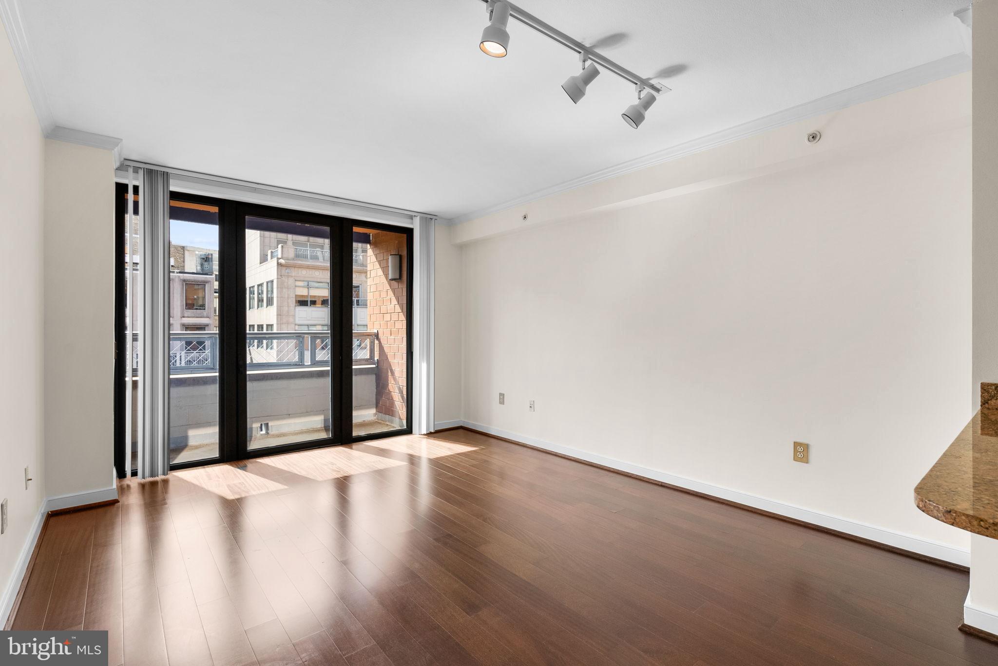 631 D Street Northwest, Unit 1129 Washington, DC 20004 - Photo 10 of 29 a view of an empty room with a window and wooden floor