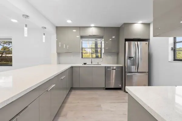 a large kitchen with a sink stainless steel appliances and cabinets